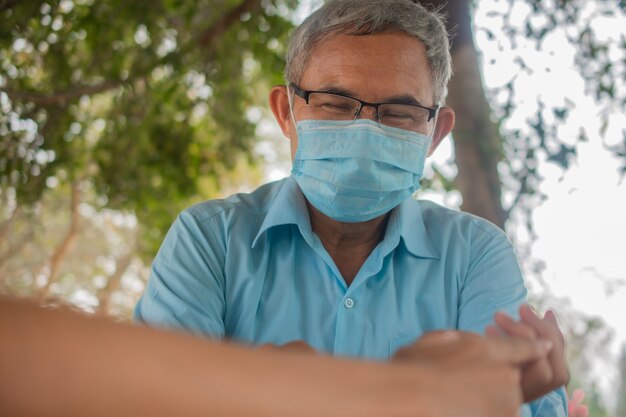 Asiatischer Mann ältere tragen Gesichtsmaske verhindern Coronavirus covid19 halten soziale Distanzierung