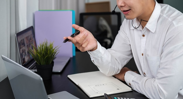 Asiatischer Mann arbeitet Callcenter-Unterstützung Online-Arbeit zu Hause über Laptop-Computer-Internet