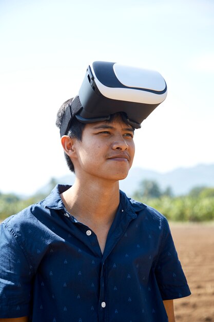 Asiatischer Mann, der den Kopfhörer der virtuellen Realität verwendet