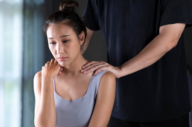 Asiatischer Mann, der die depressive Frau tröstet Ehemann, der versucht, seine Frau zu Hause zu trösten