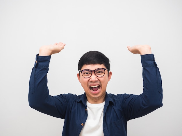 Asiatischer Mann, der eine Brille trägt, die wütende Emotionsgeste trägt, trägt etwas auf dem weißen Hintergrundkopierraum des Kopfes