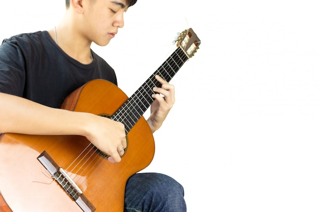 Asiatischer Mann, der eine klassische Gitarre lokalisiert auf schwarzem Hintergrund spielt.