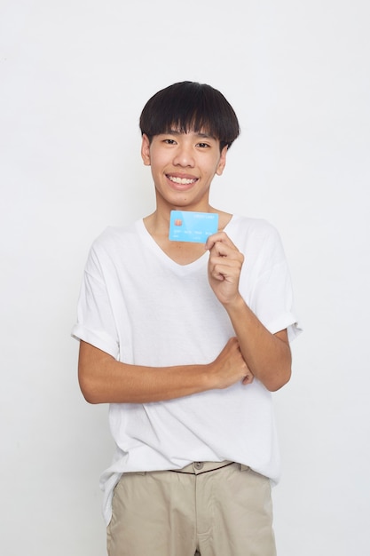 Asiatischer Mann, der Kreditkartenzahlungskonzept lokalisiert auf weißer Oberfläche zeigt