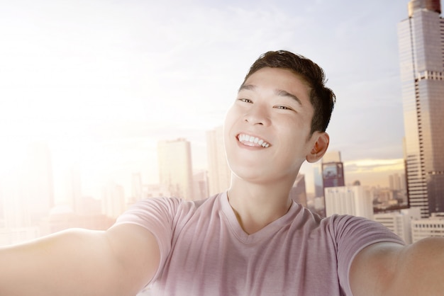 Asiatischer Mann, der Selfie mit seinem Smartphone macht