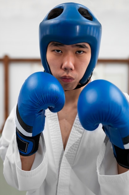 Asiatischer mann der vorderansicht, der taekwondo übt