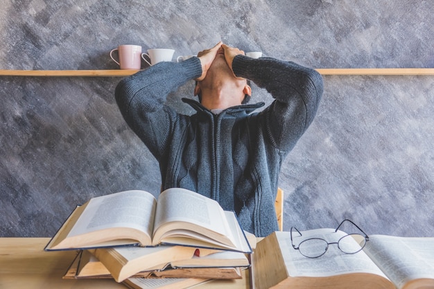 Asiatischer Mann gelangweiltes gelesenes Buch im Wohnzimmer