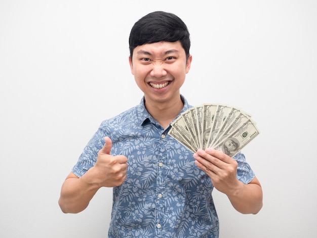 Asiatischer mann glück daumen hoch mit viel geld in der hand isoliert