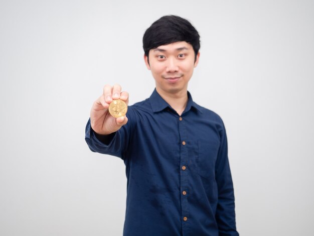 Asiatischer Mann glückliches Gesicht zeigt Goldbitcoin in seiner Hand weißer Hintergrund