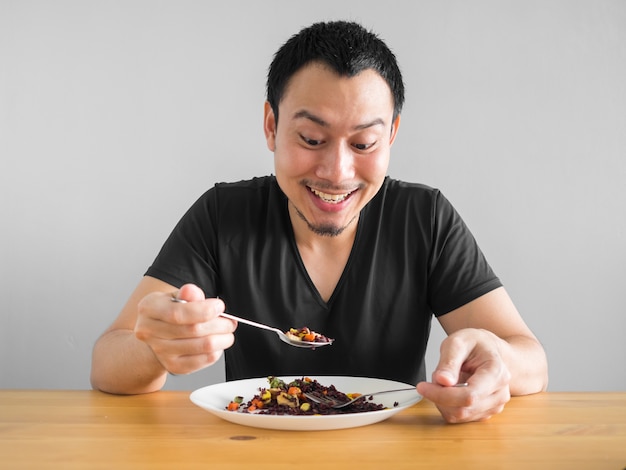 Asiatischer Mann isst sauberes Lebensmittel für das gute gesunde Leben.
