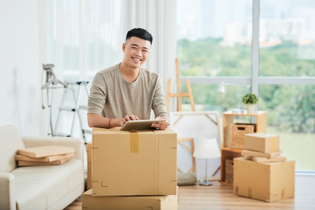 Asiatischer Mann mit gepackten Kisten