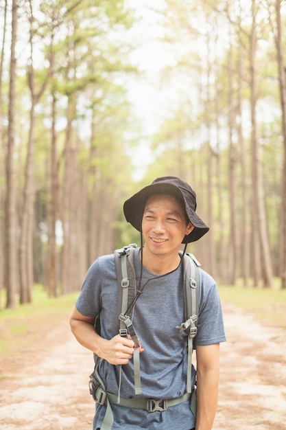 Asiatischer Mann mit Rucksackwanderung im Wald