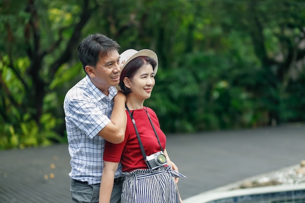 Asiatischer mann mittleren alters, der sich mit seiner frau am hochzeitstag entspannt?