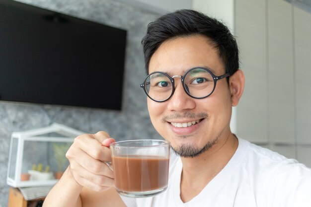 Asiatischer Mann selfy trinkt selbst Kaffee.