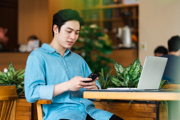 Asiatischer Mann sitzt und trinkt Kaffee