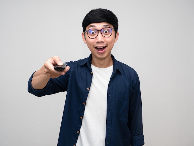 Asiatischer Mann trägt eine Brille, die von der Verwendung der Fernbedienung in der Hand begeistert ist