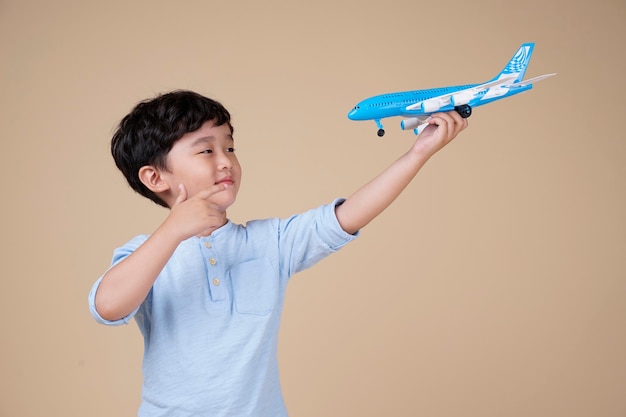 Asiatischer niedlicher kleiner Junge halten ein Flugzeugspielzeug