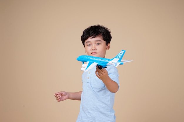 Asiatischer niedlicher kleiner Junge halten ein Flugzeugspielzeug