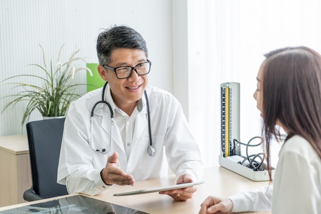 Asiatischer Oberarzt und Patient diskutieren