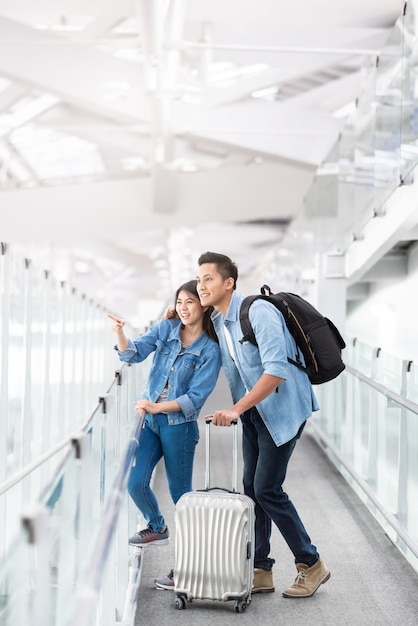 Asiatischer Paarreisender mit Gepäck am Flughafen