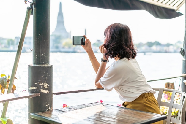 Asiatischer Reisender, der ein Foto im Café macht