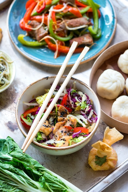 Asiatischer Salat mit Hühnchenpfanne, Bok Choy, Kohl und Pfeffer, Dim Sum Bowl, Frühlingsrollen