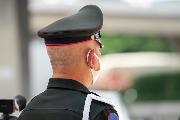 Asiatischer Soldat in rückwärtiger Uniform steht zur Beobachtung und achtet auf Schutz rundherum