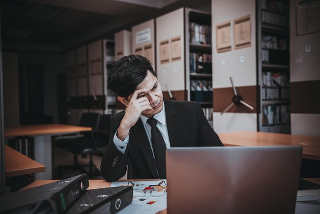 Asiatischer Stressgeschäftsmann, der scheitert Der Eigentümer der Firma beschuldigte ihn mit einem schlechten Wort