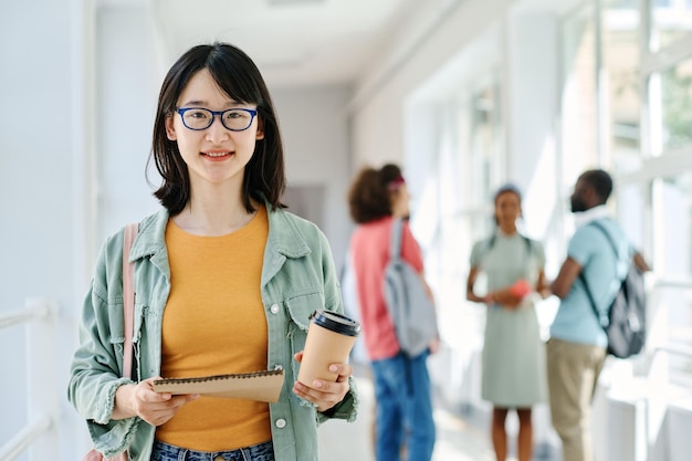 Asiatischer Student, der am Korridor steht