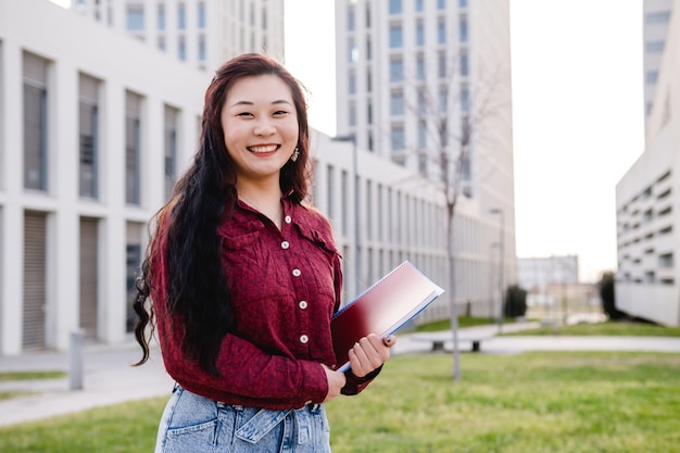 Asiatischer Student der jungen Frau am Universitätscampuskopierraum