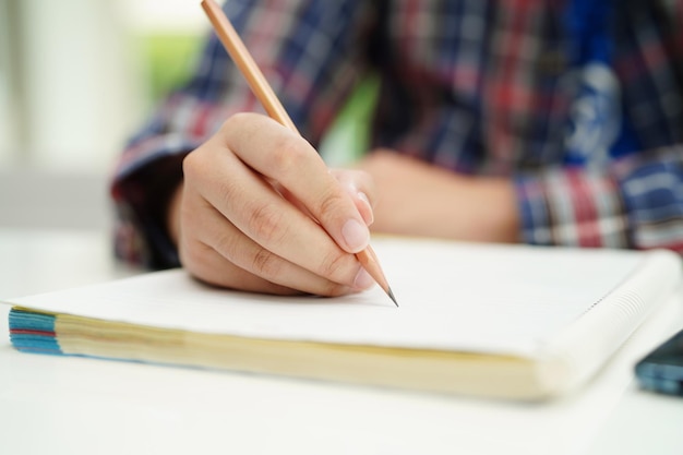 Asiatischer Teenager schreibt Hausaufgaben, studiert Unterricht für die Prüfung, lernt Online-Bildung