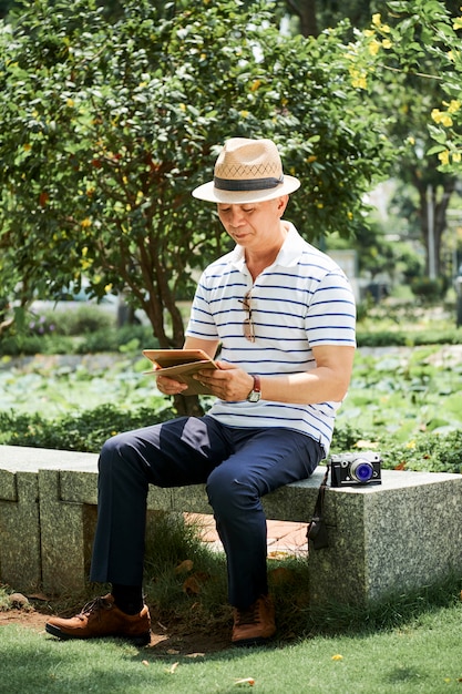 Asiatischer Tourist mit Tablet-PC im Freien