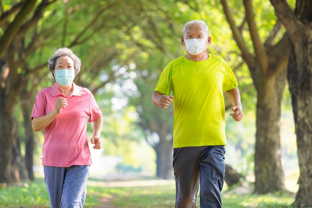 Asiatisches älteres Paar mit Gesichtsmaske und Joggen im Park