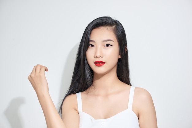 Asiatisches Aussehen der jungen Frau mit schwarzem Haar steht isolierten weißen Hintergrund im Studio.