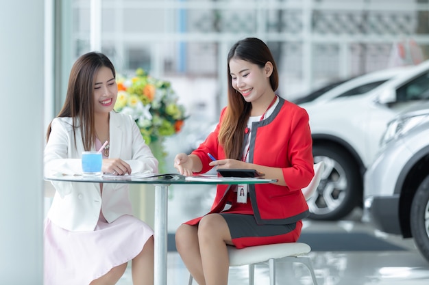 Asiatisches Autogeschäft, Autoverkauf, Technologie und Leutekonzept - glückliches Paar mit Auto.