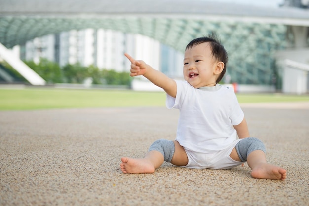 Asiatisches Baby, das in Park kriecht