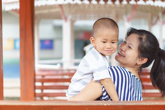 Asiatisches Baby, das von seiner Mutter gehalten wird