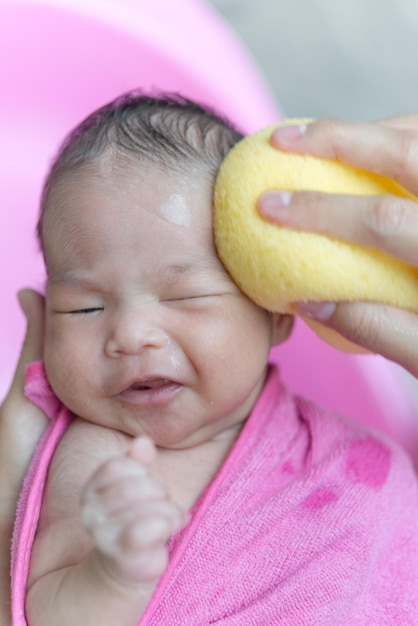 Asiatisches Baby der Nahaufnahme duscht bei Tageslicht