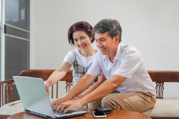 Asiatisches Ehepaar mittleren Alters arbeitet von zu Hause aus