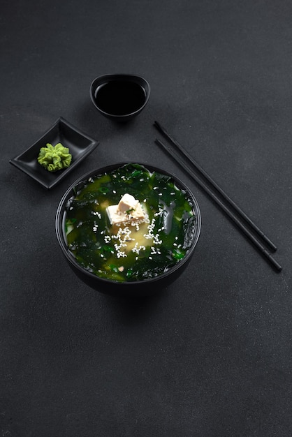 Asiatisches Essen der Muso-Suppe auf einem vertikalen Smartphone-Bildformat des dunklen Hintergrundes für Storis