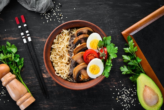 Asiatisches Essen Nudeln mit Pilzen, Eiern und Chiasamen auf einem hölzernen Hintergrund Draufsicht Freier Kopierbereich