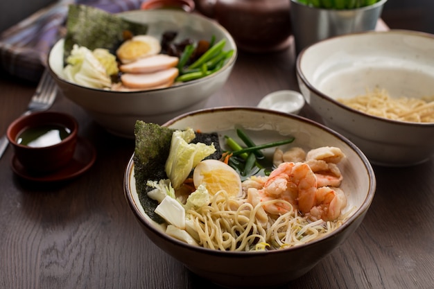 Asiatisches essen: ramen mit huhn und garnelen auf dem tisch