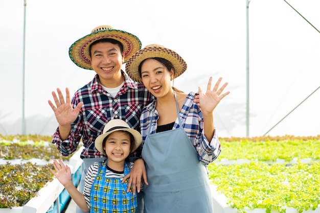 Asiatisches Familienlächeln und Glück mit ihrem landwirtschaftlichen Geschäft. Biolandwirtschaft im Gewächshaus.