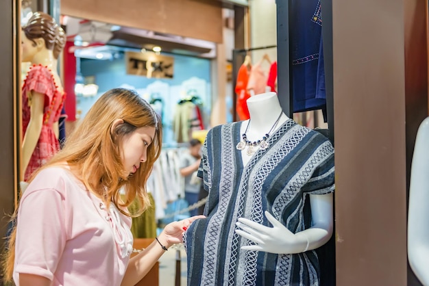 Asiatisches Hippie-Mädchen, das im Kaufhaus einkauftGlückliche Frau mit Einkaufstüten in der Hand im EinkaufszentrumThailänderDamen kaufen gerne das Beste