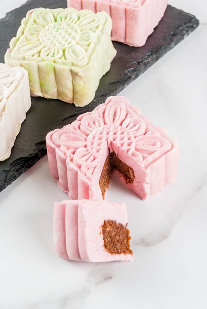 Asiatisches, japanisches Lebensmittel, die traditionelle mehrfarbige Süßspeise backen keine Schneehaut Mooncakes auf weißer Marmortabelle. kopieren sie platz