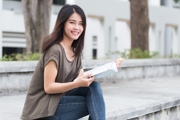 Asiatisches jugendlich Frauenlesebuchglück und -lächeln genießen Bildung in der Universität