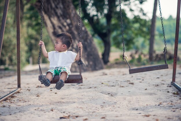 Asiatisches Jungenspiel des Kindes auf dem Spielplatz