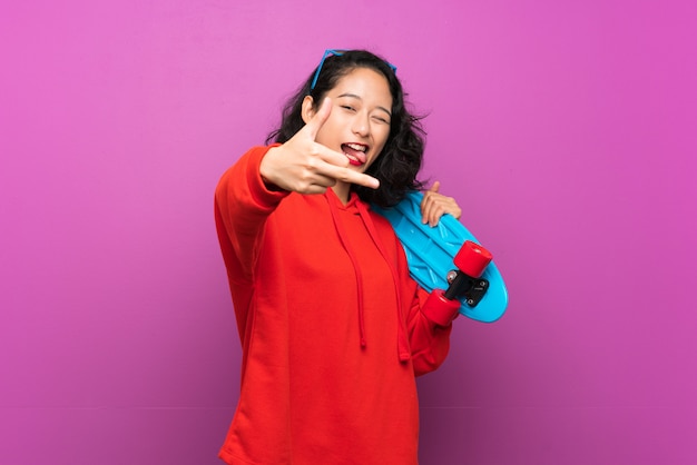 Asiatisches junges Mädchen mit Rochen über purpurroter Wand