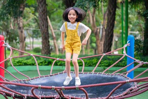 Asiatisches Kind, das am Park spielt