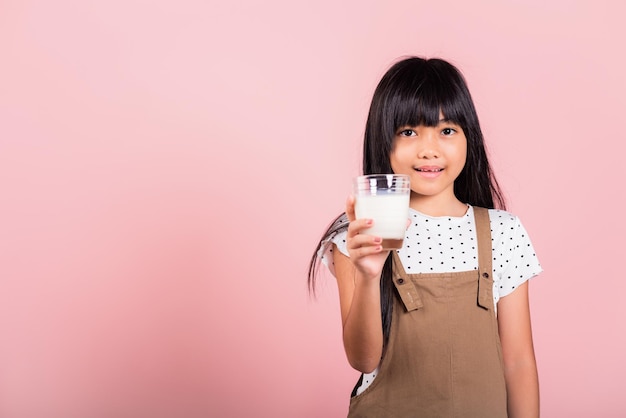 Asiatisches kleines Kind 10 Jahre alt Lächeln halten Milchglas trinken weiße Milch