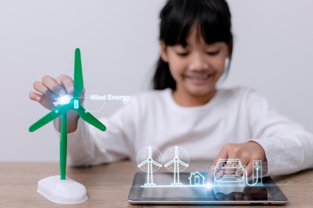 Asiatisches kleines Mädchen arbeitet mit Windturbinen-Prototyp virturl Lernen über Umwelt und erneuerbare Energien Kinder arbeiten an Technologie Windenergiekonzept MINT-Bildung